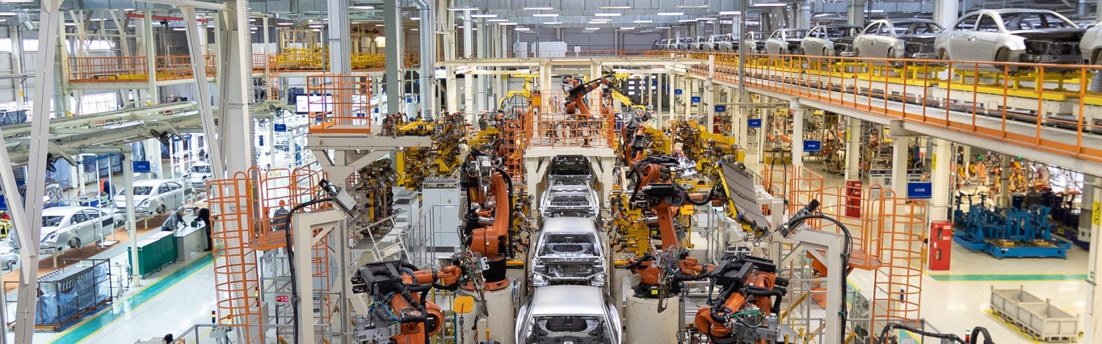 Assembly line production of new car. Automated welding of car body on production line. robotic arm on car production line is working. Wide format shooting automotive. Car factory banner